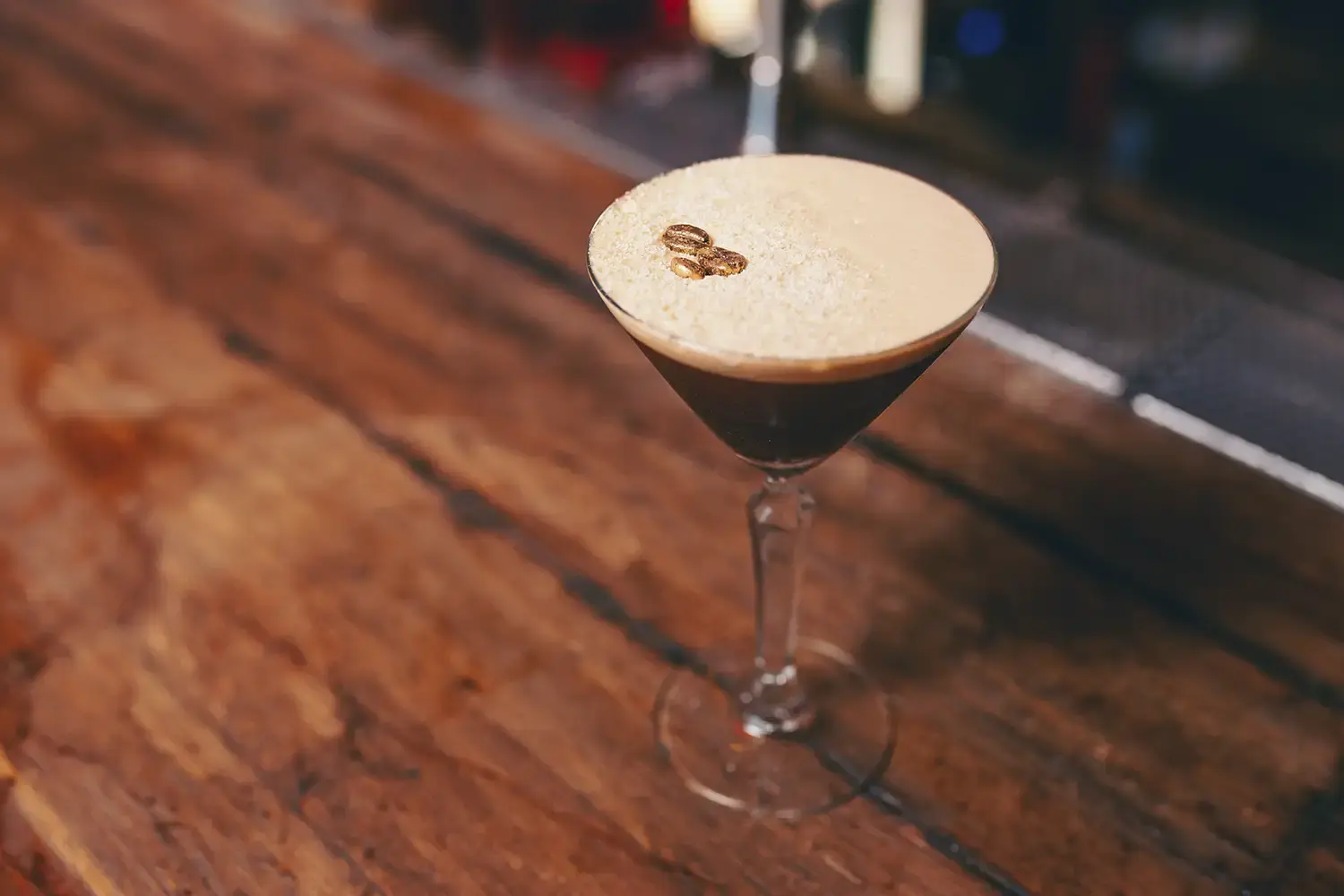 An espresso martini on a bar with a coffee bean garnish