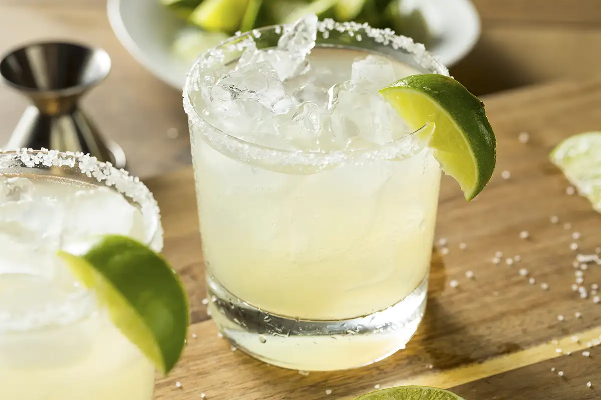 A margarita with salted rim and lime garnish