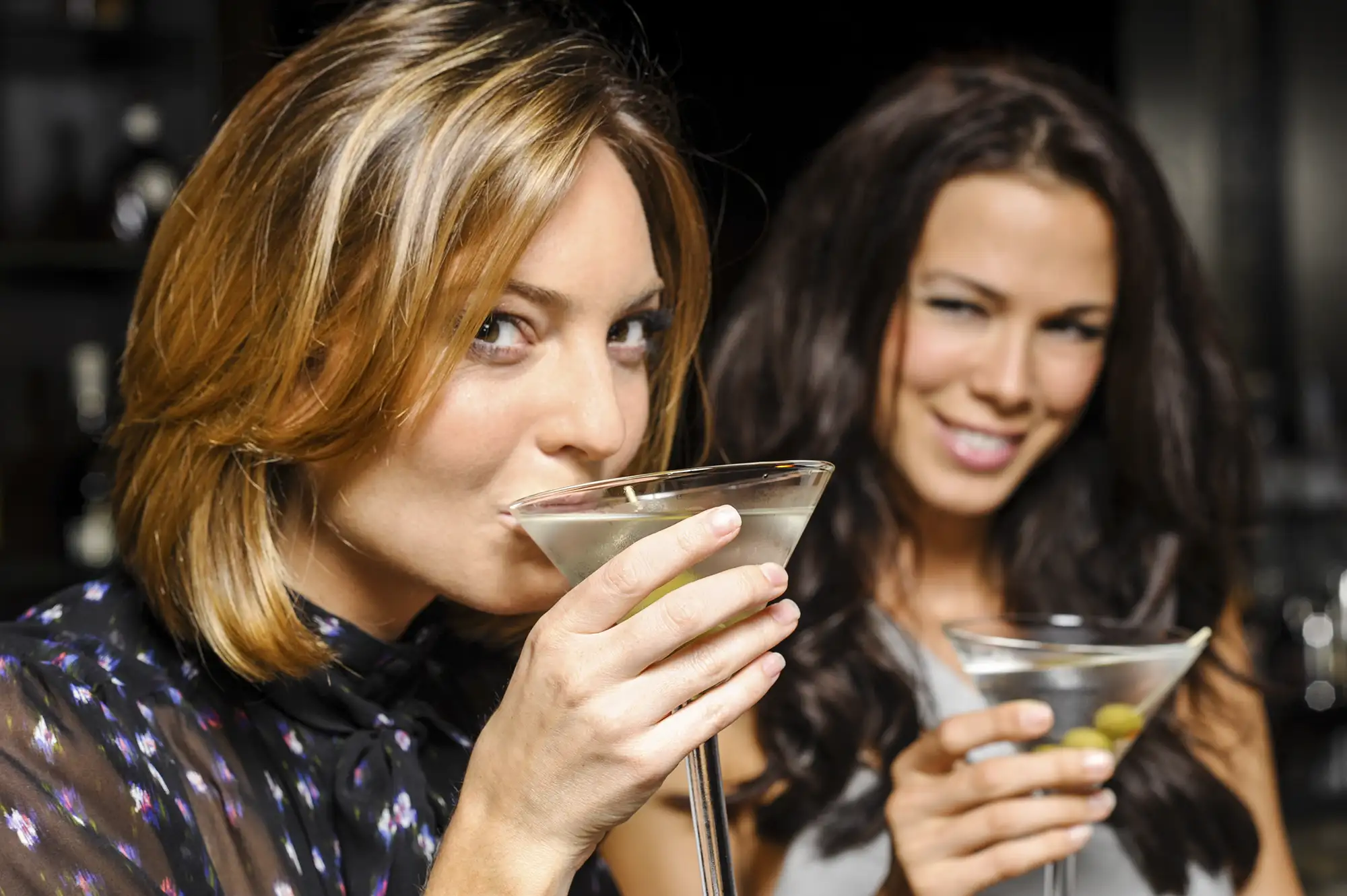 Two woman enjoying a martine mixed cocktail