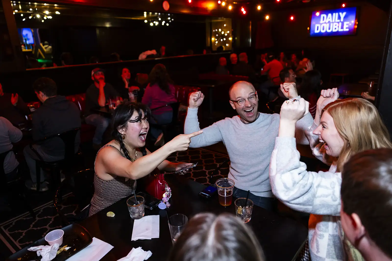 A group of friends engaged and enjoying a trivia night