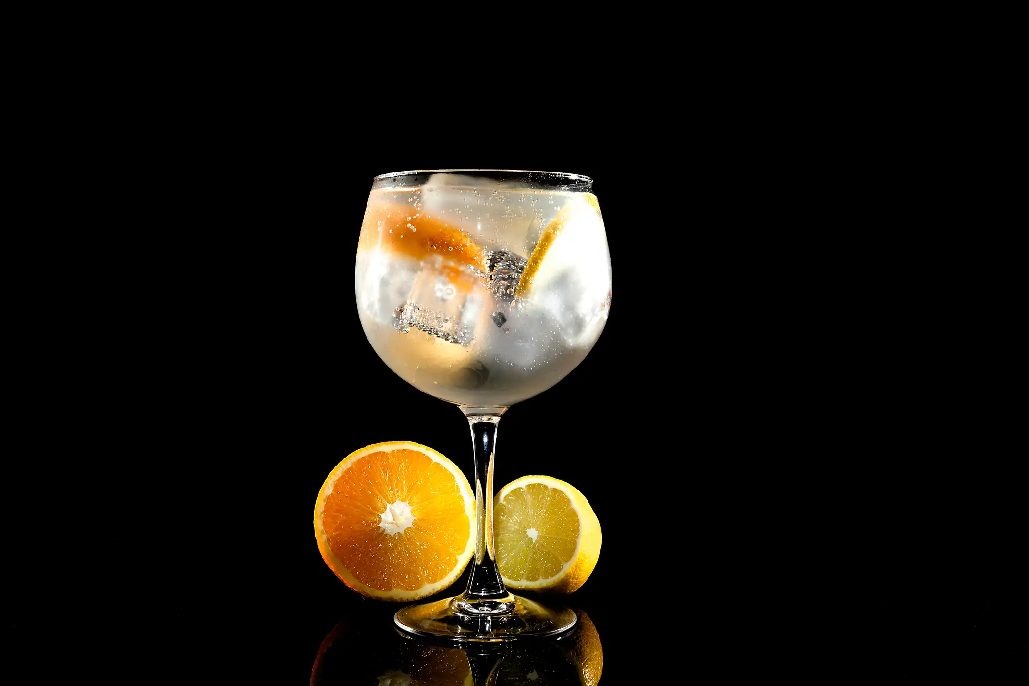 A mixed drink cocktail made with gin or vodka featuring an orange and lemon garnish